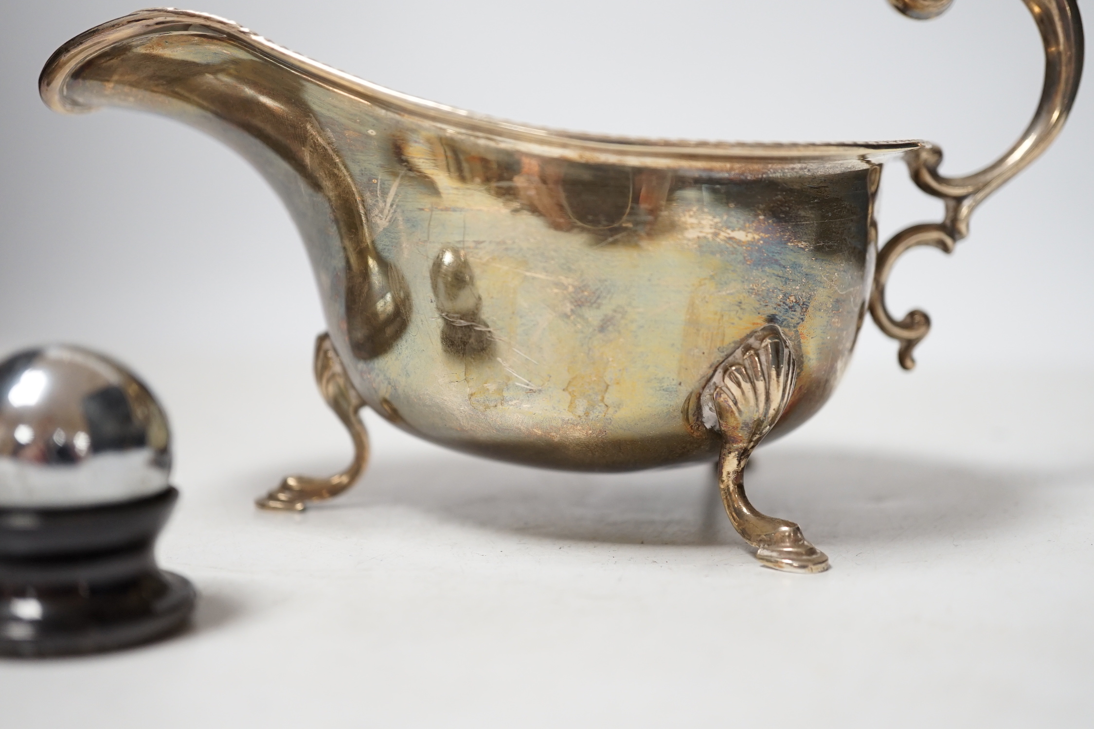 A 1930's silver sauceboat a silver mounted inkwell and one other item.
